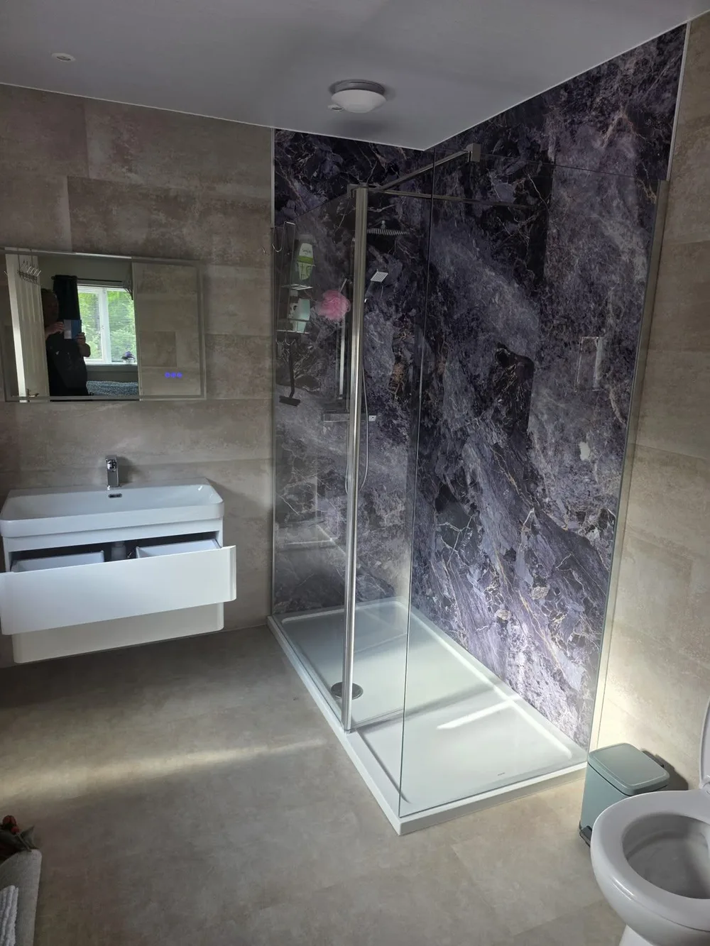 Shower lined in dark marble-effect wet wall panelling